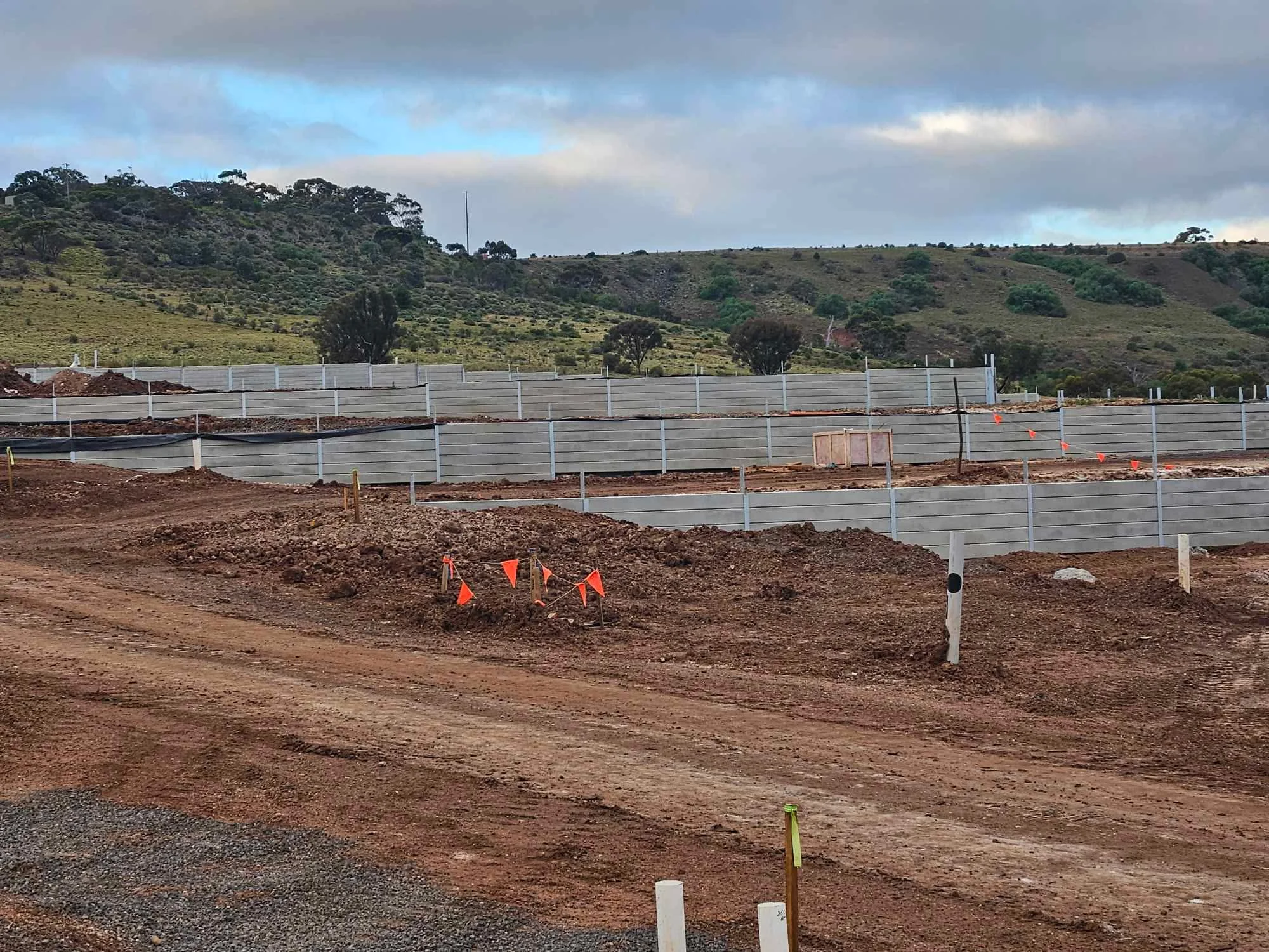 Massive multi-tier grey sleeper retaining wall stepping across a hillside, built by Align Excavation Group